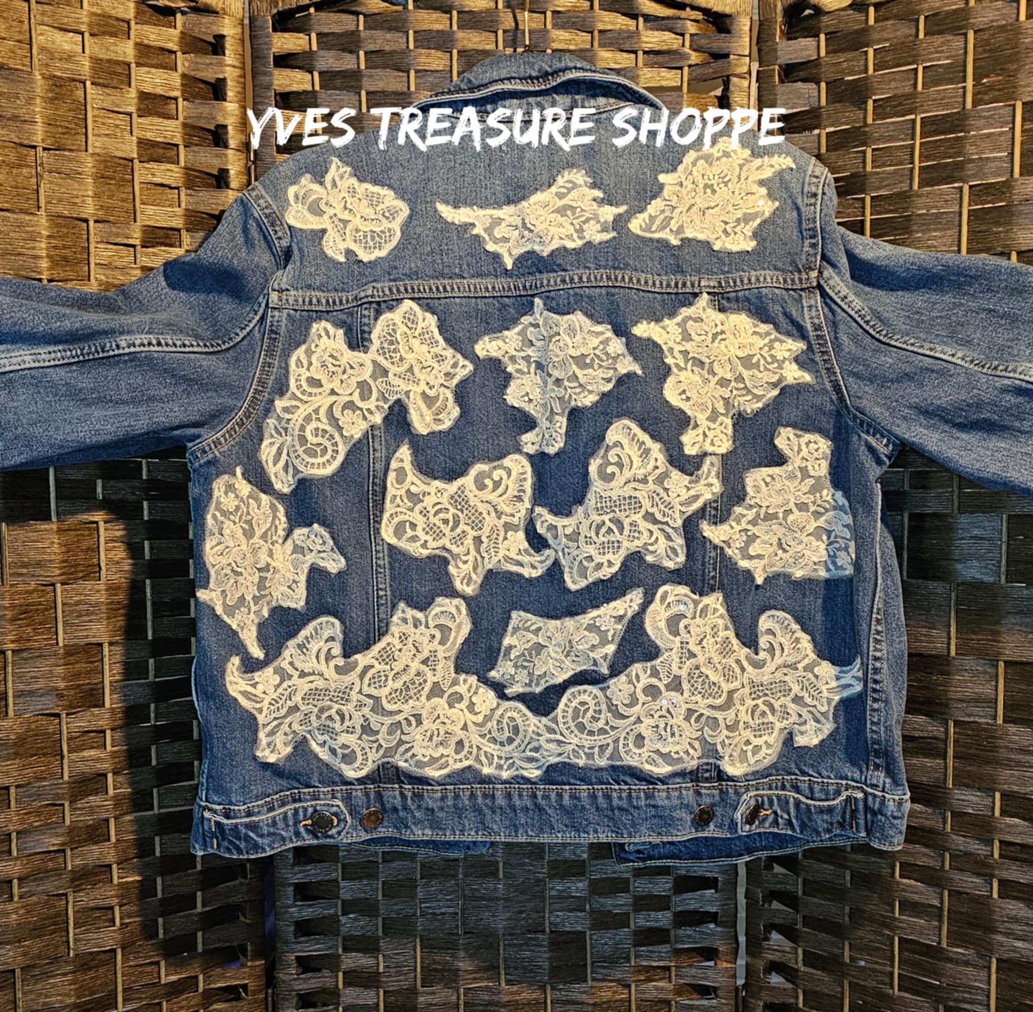 Blue denim jacket with white lace patterns on a woven surface, branded 'Yves Treasure Shoppe'.